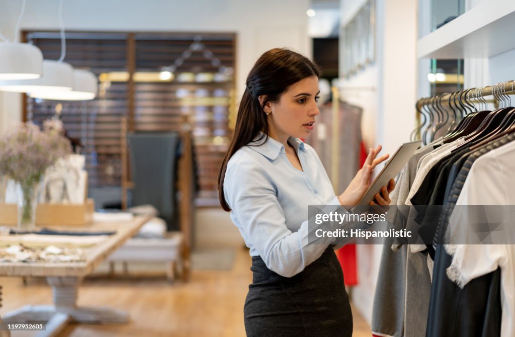 Latin American Sales Woman Working At A Clothing Store Checking