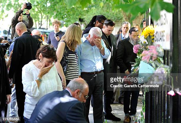 Amy Winehouse's father Mitch Winehouse mother Janis Winehouse brother Alex Winehouse and former boyfriend Reg Traviss look at floral tributes left at...