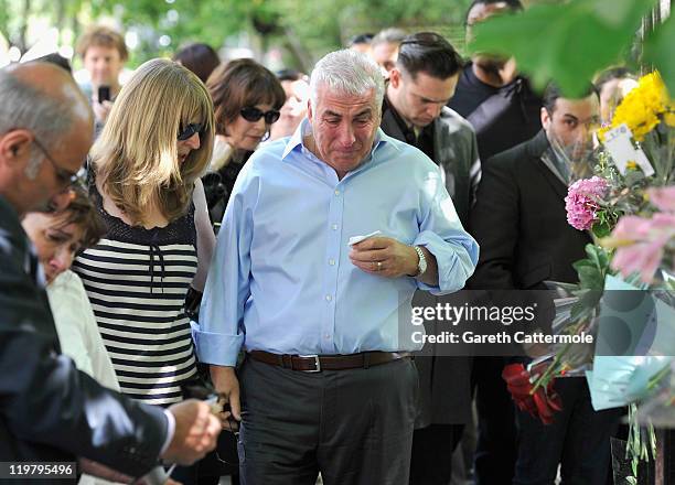 Amy Winehouse's father Mitch Winehouse mother Janis Winehouse brother Alex Winehouse and former boyfriend Reg Traviss look at floral tributes left at...