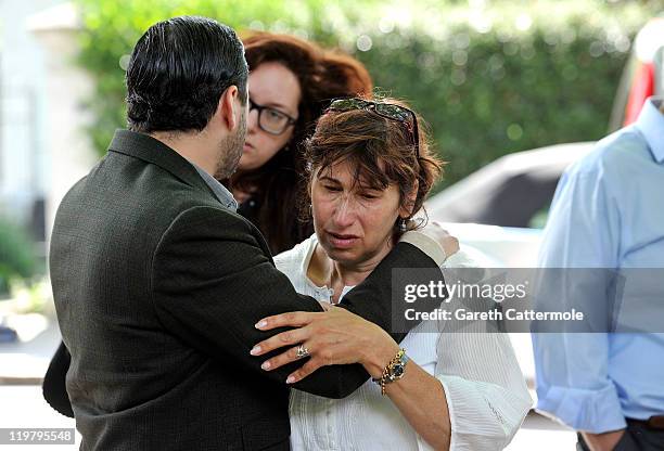 Amy Winehouse's mother Janis Winehouse is comforted by her son Alex Winehouse as she looks at floral tributes left at her house by fans on July 25,...