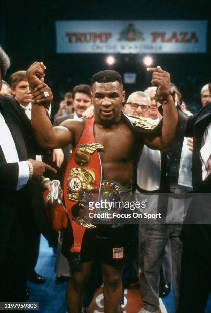 Mike Tyson celebrates wearing all three belts after he defeated Larry Holmes for the WBA, WBC and IBF heavyweight tittles on January 22, 1988 at the...