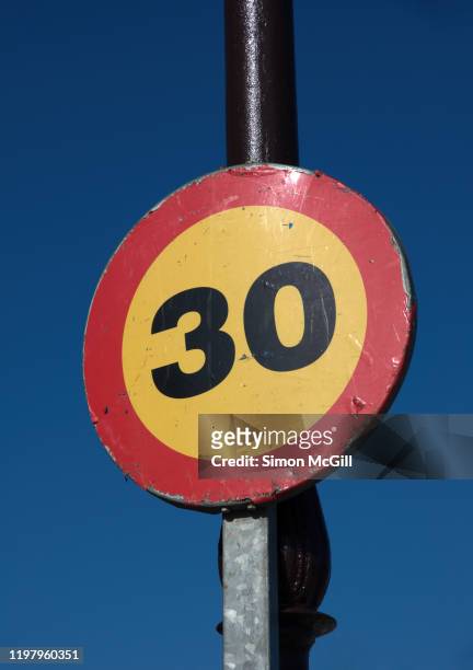 30 kilometre per hour speed limit sign against a clear blue sky - kilometer stockfoto's en -beelden