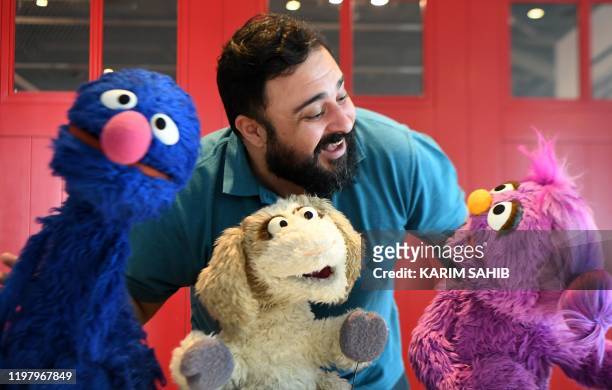 Hadi, the name of the character portrayed by a Jordanian actor Rami Delshad, poses for a picture with Grover , Mazooza and Basma from the Sesame...