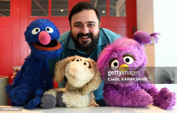 Hadi, the name of the character portrayed by a Jordanian actor Rami Delshad, poses for a picture with Grover , Mazooza and Basma from the Sesame...