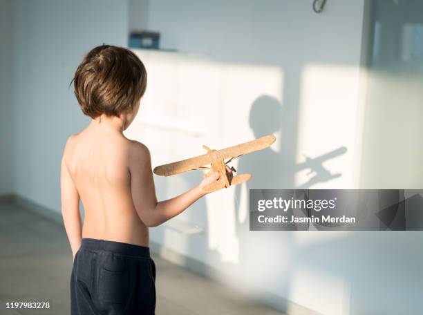 playful kid with airplane toy - plane shadow stock pictures, royalty-free photos & images