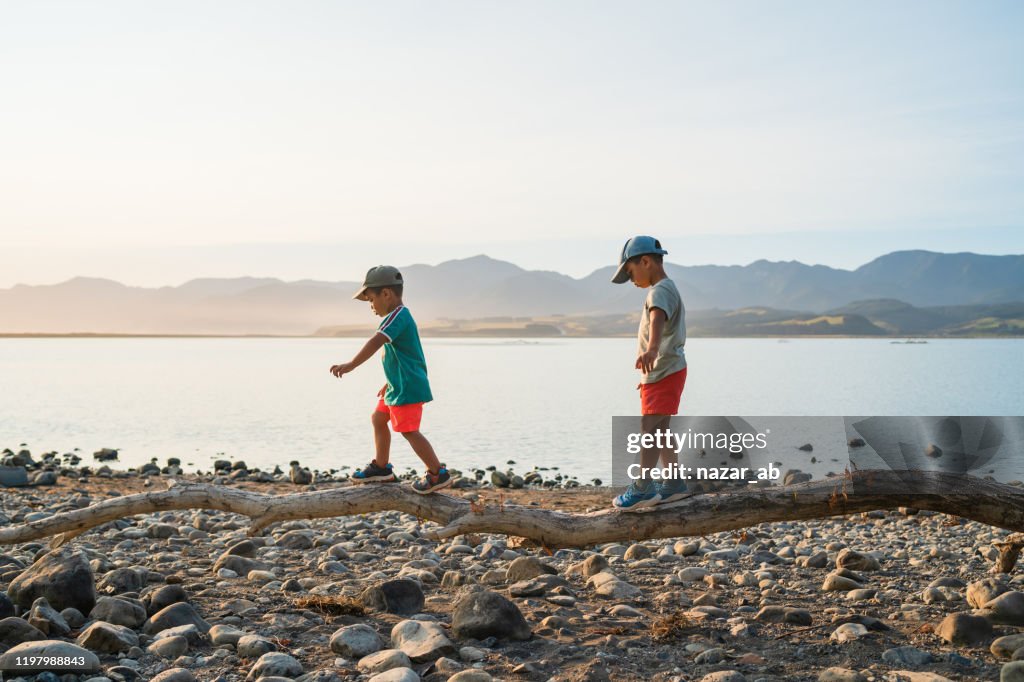 Kids walking on log trying to balance.