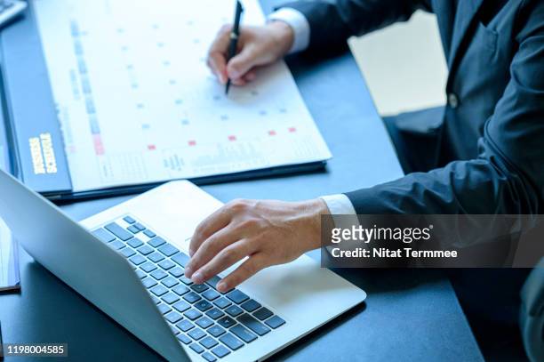 close-up of businessman making a notes schedule meeting at calendar during work. - personal organiser 個照片及圖片檔