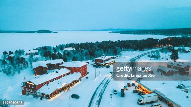 scenic aerial view of road through inari village and forest in winter, lapland, finland. - inari finland bildbanksfoton och bilder