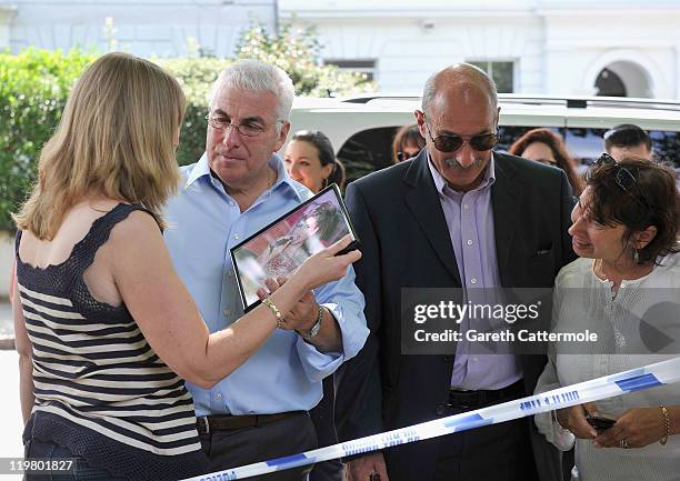 Amy Winehouse's mother Janis Winehouse and Amy's father Mitch Winehouse and his second wife Jane look at tributes left at her house by fans on July...