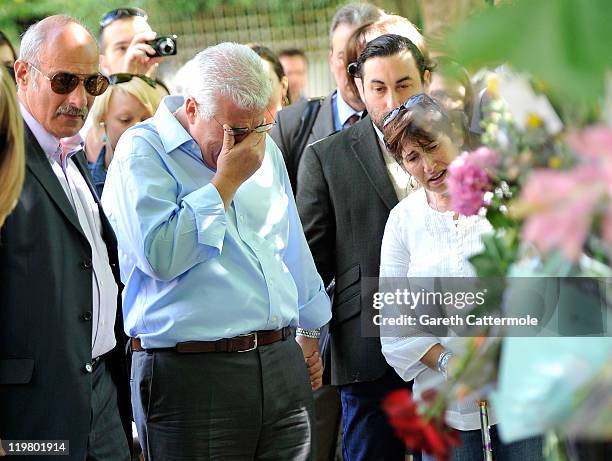 Amy Winehouse's father Mitch Winehouse brother Alex Winehouse and her mother Janis Winehouse look at floral tributes left at her house by fans on...