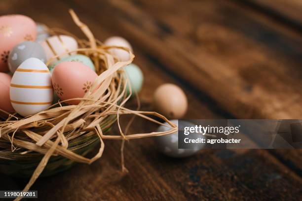 ostern dekoration auf holztisch - eggs in basket stock-fotos und bilder