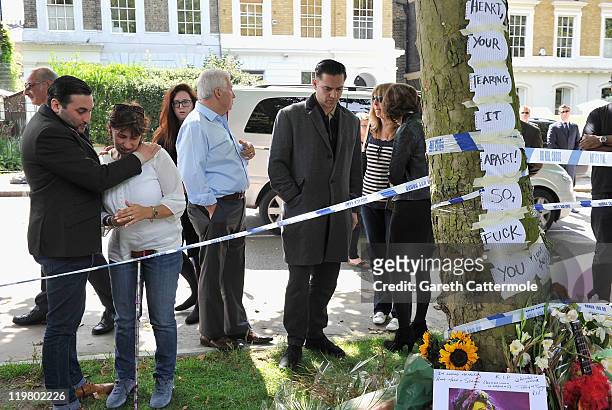 Amy's father Mitch Winehouse and mother Janis Winehouse look at floral tributes with theri son Alex Winehouse Amy's former boyfriend Reg Traviss at...