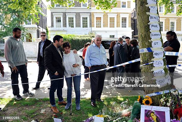 Amy's father Mitch Winehouse and mother Janis Winehouse look at floral tributes with their son Alex Winehouse at Amy's house on July 25, 2011 in...