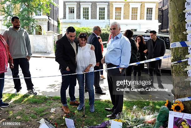 Amy Winehouse's father Mitch Winehouse , mother Janis Winehouse and brother Alex Winehouse look at floral tributes left at Amy's house by fans on...