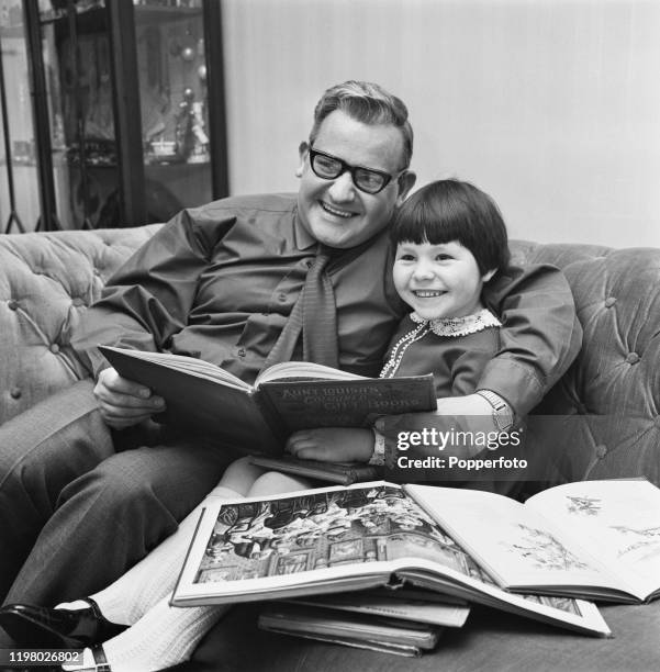 English actor, comedian and writer Ronnie Barker reads a book with his daughter Charlotte at home in May 1968.