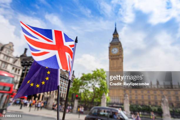 europäische flagge weht neben dem british union jack vor den houses of parliament, westminster, london. - brexit stock-fotos und bilder