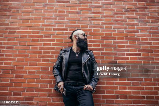 bearded kerel in zwarte kleding - kaal geschoren hoofd stockfoto's en -beelden