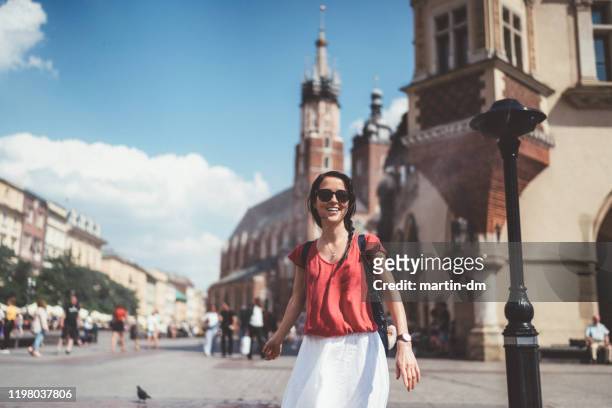toeristische vrouw genieten van sprinkler in warme dag - krakow poland stockfoto's en -beelden