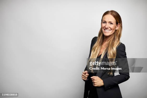 smiling businesswoman in black business casual - three quarter length stock pictures, royalty-free photos & images