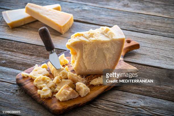 parmesan reggiano cheese on cutting board - parmesan imagens e fotografias de stock