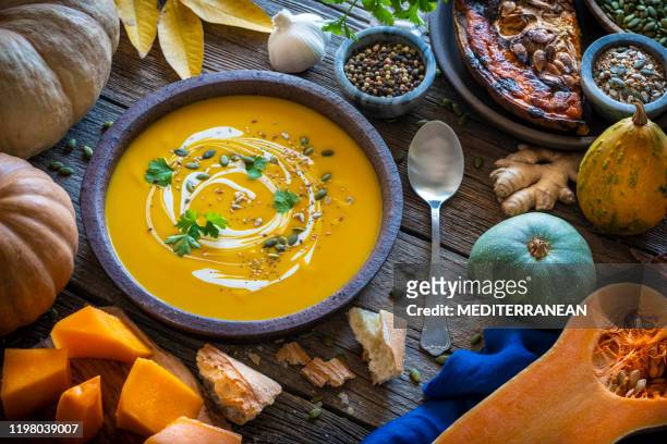 autumn pumpkin soup and ingredients on wood - soup stock pictures, royalty-free photos & images