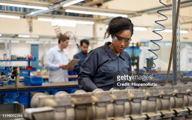 african american young woman working at an assembly production of water pumps at a factory - manufacturing stock pictures, royalty-free photos & images