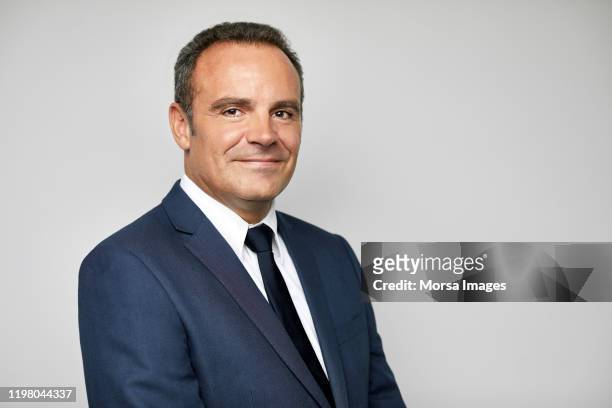 smiling mature businessman with arms crossed - pak stockfoto's en -beelden