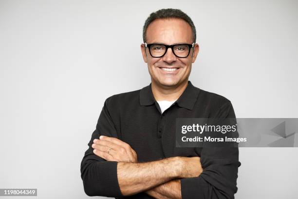 smiling mature male ceo with arms crossed - male fashion fotografías e imágenes de stock