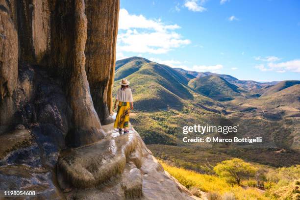 tourist exploring the petrified waterfalls at hierve el agua, oaxaca, mexico - verwonderingsdrang stockfoto's en -beelden