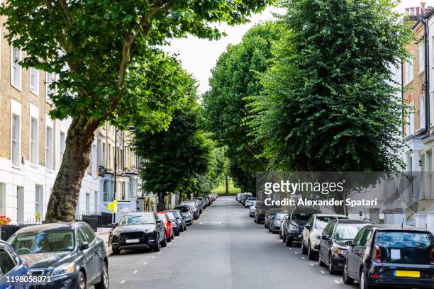 street with residential building and parked cars in primrose hill district, london, england, uk - uk road stock pictures, royalty-free photos & images
