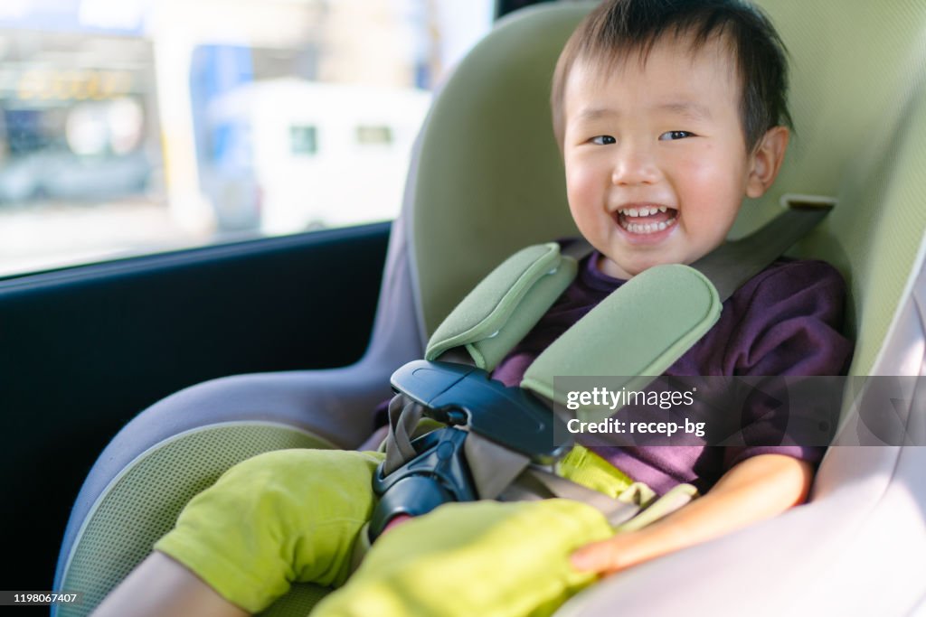 Small baby boy in safety seat in car