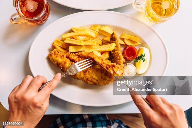 man eating fish and chips in a pub, personal perspective directly above view - fish chips stockfoto's en -beelden