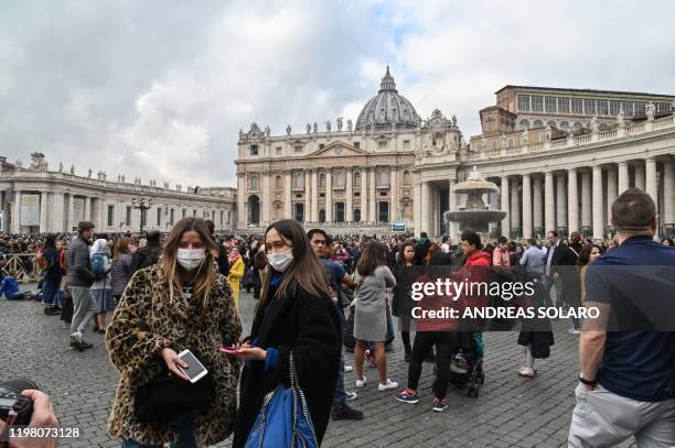 Tourist wearing protective respiratory masks tour St. Peter's Square prior to the Pope's weekly Angelus prayer on February 2, 2020 in the Vatican. -...