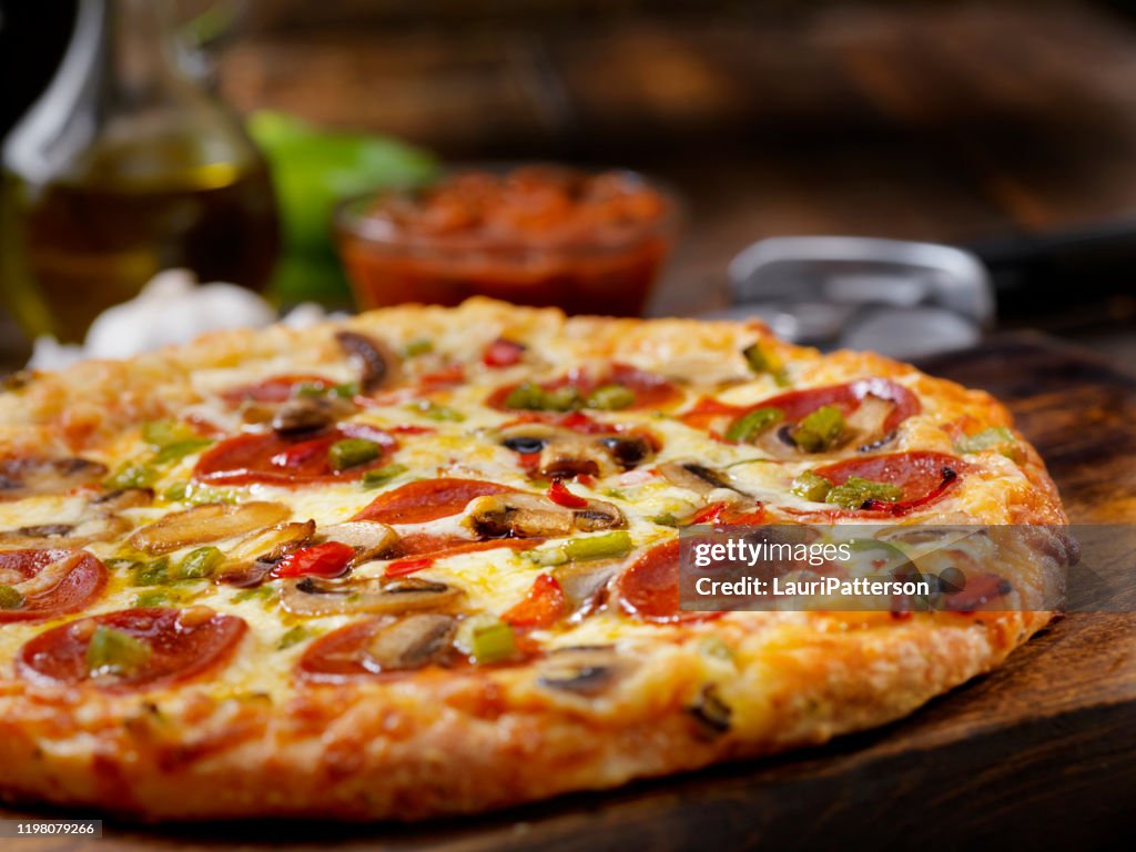 Deluxe pizza met pepperoni, worst, champignons en paprika