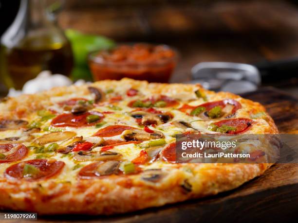 deluxe pizza with pepperoni, sausage, mushrooms and peppers - flatbread pizza stock pictures, royalty-free photos & images