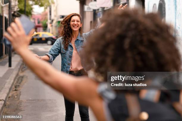 best friends meeting and embracing - wave hello outside stock pictures, royalty-free photos & images