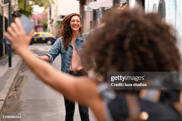 best friends meeting and embracing - greeting friends stock pictures, royalty-free photos & images