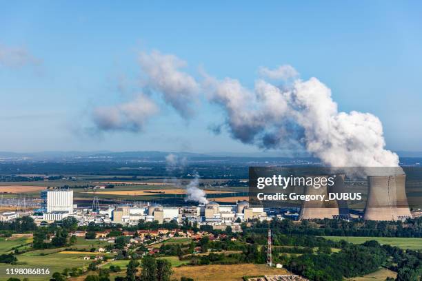 français vue aérienne de centrale nucléaire dans le paysage de campagne en été avec des tours de refroidissement fumantes sur le ciel bleu - centrale nucléaire photos et images de collection