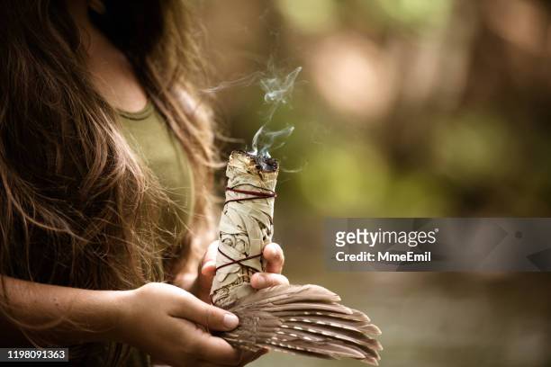 alternative medecine, young woman performing a purification ritual with sage - ceremony imagens e fotografias de stock