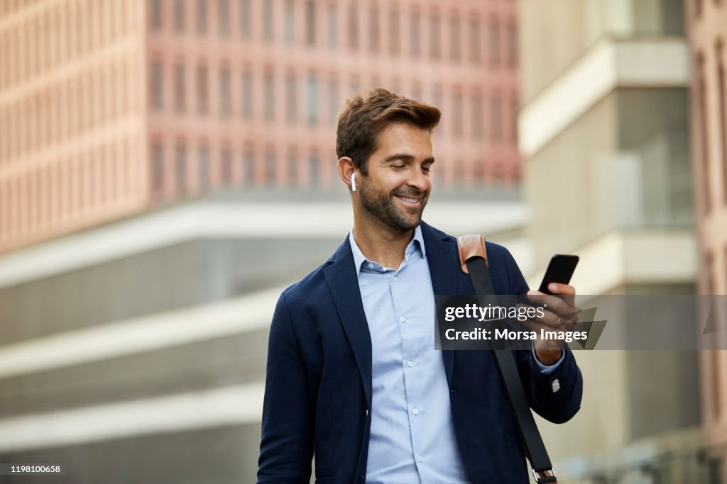 Smiling handsome male entrepreneur surfing net