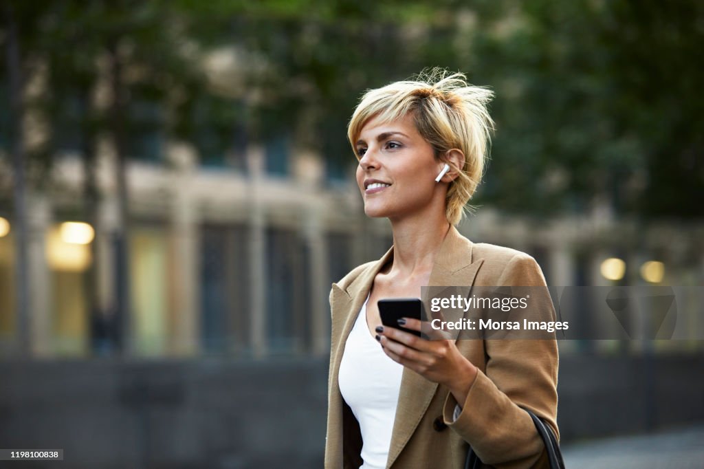 Beautiful young businesswoman holding smart phone