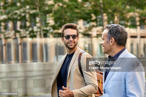 confident male entrepreneurs talking in city - homens de idade mediana imagens e fotografias de stock