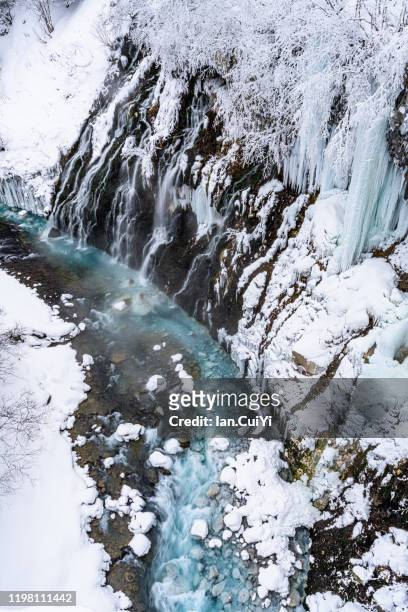 shirahige waterfalls in winter. also known as the "white beard waterfall," this cascading water turns cobalt blue in the basin, biei, hokkaido, japan. - frozen waterfall stockfoto's en -beelden