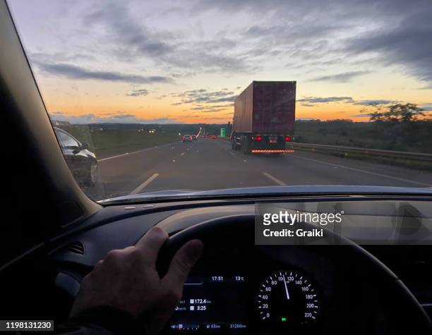 point of view of a driver on the highway by sunset - windschutzscheibe stock-fotos und bilder