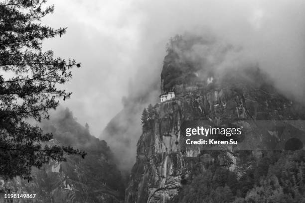paro taktsang (also known as tiger's nest) perched on the cliff in morning mist, paro, bhutan - disparo bildbanksfoton och bilder