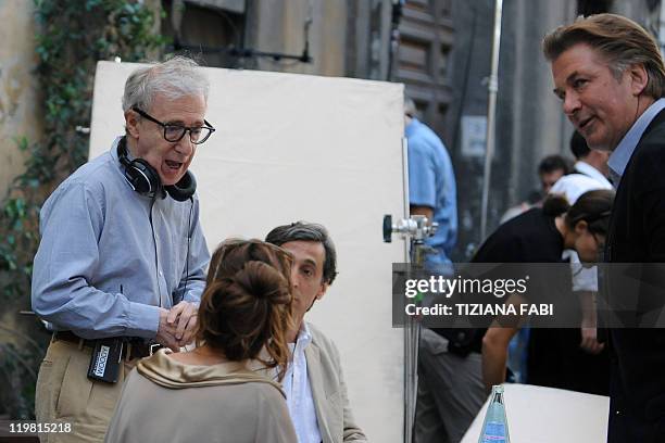 Film director Woody Allen speaks to US actor Alec Baldwin and US actress and model Carol Alt at a terrace at Piazza della Pace in central Rome during...