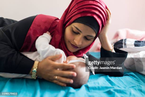 east asian mother and baby in bedroom - ramadan in india stock-fotos und bilder