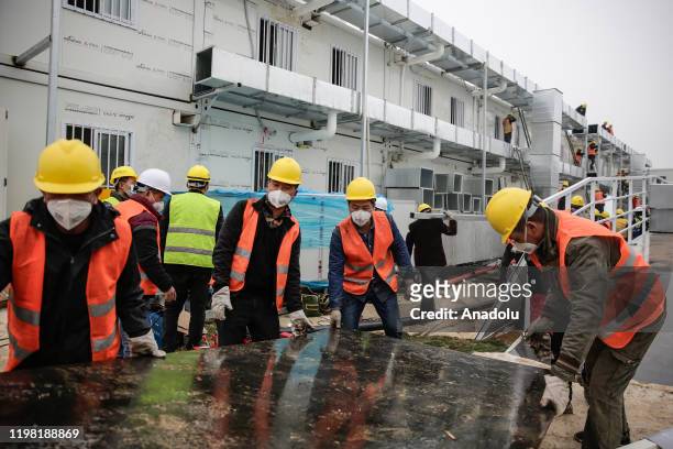 Workers build hospital on February 3, 2020 in Wuhan, China. After only 10 days of construction, Wuhan Huoshenshan Hospital was officially completed...