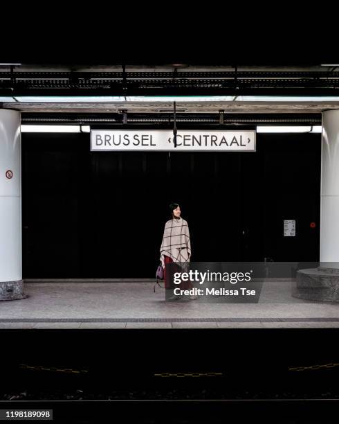 woman waiting for train in brussels central station - brussels stock-fotos und bilder