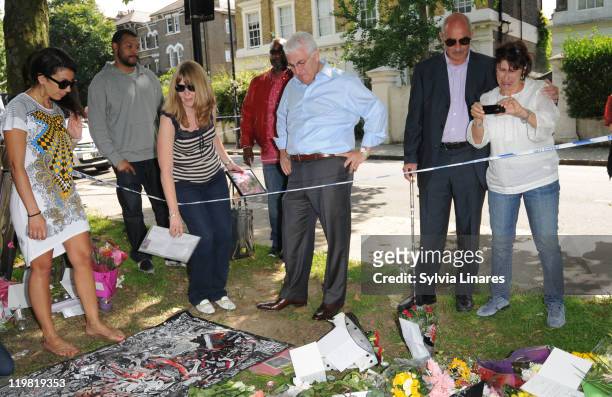Amy Winehouse's father Mitch Winehouse and mother Janis Winehouse are seen looking at the floral tributes outside her Camden Square home on July 25,...